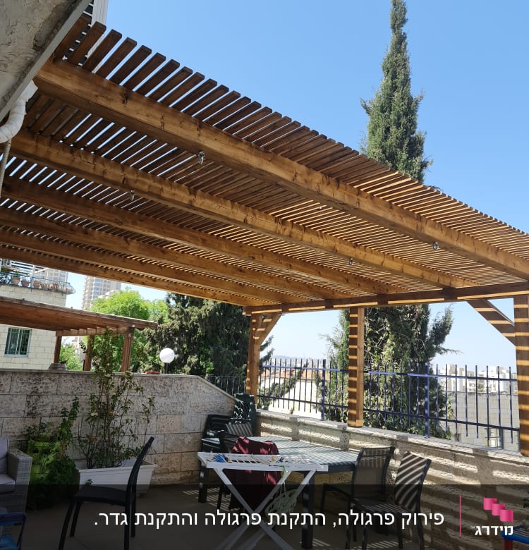 פרגולה מעץ עם כיסאות ושולחן בגינה